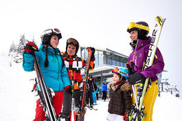 Eine Gruppe von Menschen steht auf einer schneebedeckten Piste in einem Skigebiet Arber im Bayerischen Wald.