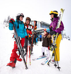 Eine Gruppe von Menschen steht auf einer schneebedeckten Piste in einem Skigebiet Arber im Bayerischen Wald.